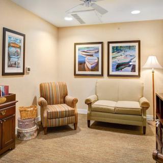 A cozy waiting room with comfortable seating and framed artwork on the walls.