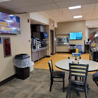 A cozy dining area in a fast food restaurant featuring a television and accessible seating.