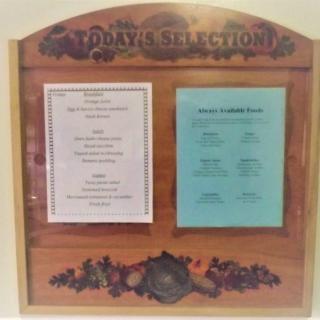 A restaurant's wine and menu options displayed on a wooden board.