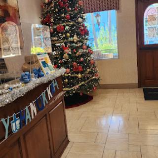 A beautifully decorated lobby featuring a vibrant Christmas tree and festive ornaments.