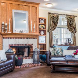 A cozy living room with a fireplace, leather sofas, and elegant decor.