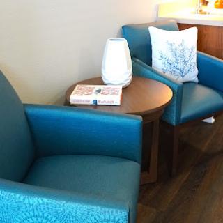 A cozy seating area featuring turquoise chairs and a wooden side table, perfect for relaxation.