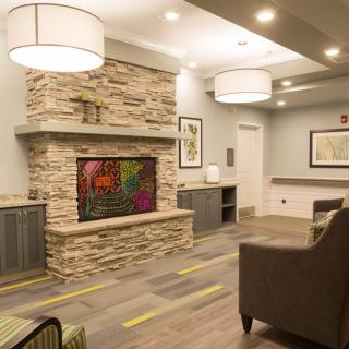 A modern and cozy living room featuring a stone fireplace and comfortable seating.