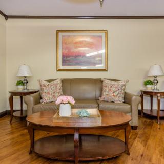 A cozy living room featuring a comfortable sofa, decorative pillows, a wooden coffee table, and elegant lamps.