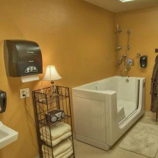 A clean, accessible bathroom with a walk-in tub and neatly stacked towels.