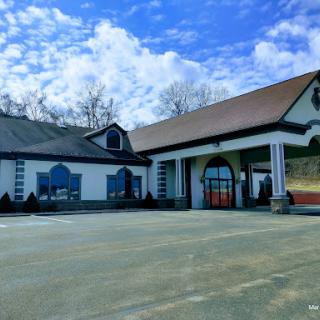 A picturesque view of a charming commercial building under a partly cloudy sky.