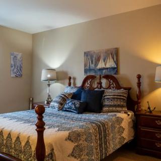 A cozy bedroom with a large bed, decorative pillows, and warm lighting.