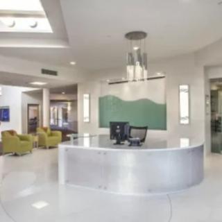 A modern office reception area with a sleek desk and contemporary lighting.