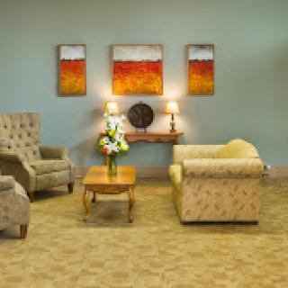 A cozy living room featuring comfortable seating and warm artwork.