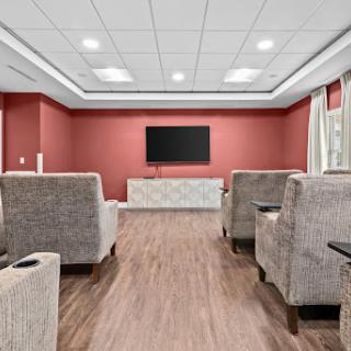 A cozy lounge area featuring comfortable seating and a wall-mounted TV.