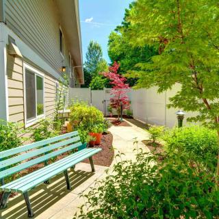 A serene garden with a bench and lush greenery alongside a pathway.