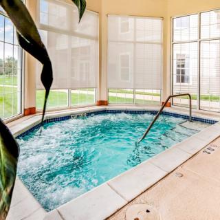 An inviting indoor jacuzzi surrounded by large windows, ideal for relaxation.