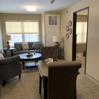A cozy living room setup with sofas, a round table, chairs, and elegant decor.