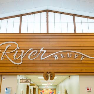 Entrance to River Bluff, featuring wood paneling and signage.
