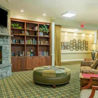 A cozy living room with a fireplace, bookshelf, and comfortable seating.