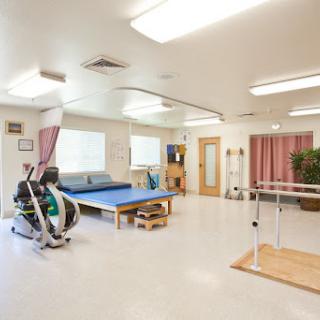 A bright and spacious physical therapy room equipped for various rehabilitation exercises.