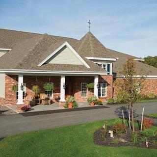A well-maintained residential building with a landscaped garden and driveway.
