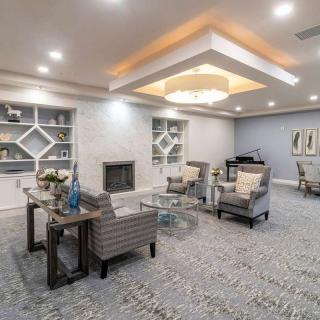 A modern living room with elegant furnishings, featuring a fireplace and a chandelier.