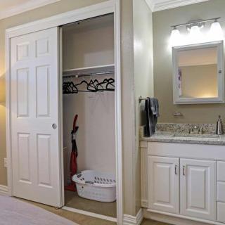 A bedroom featuring a closet with sliding doors and a built-in vanity area with a sink and mirror.