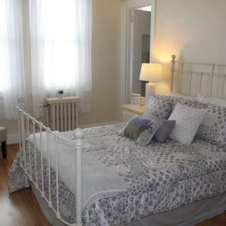 A cozy, well-lit bedroom with a neatly made bed and soft lighting.