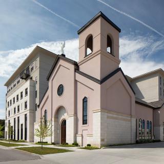 A modern church building with a bell tower against a clear blue sky.