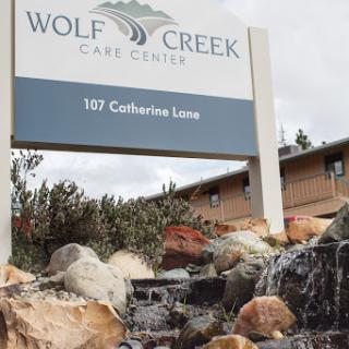 The entrance sign of Wolf Creek Care Center, surrounded by natural elements.