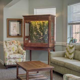 A cozy living room with a large aquarium, comfortable seating, and elegant decor.