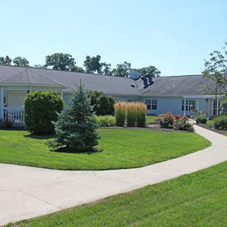 A single-story house surrounded by a well-maintained lawn and pathway.