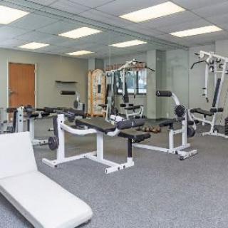 A modern gym with various exercise equipment and machines.