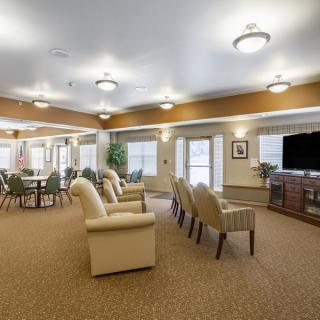 A spacious community room with comfortable seating and a large television.