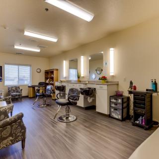 A spacious and well-lit beauty salon with multiple chairs and mirrors.
