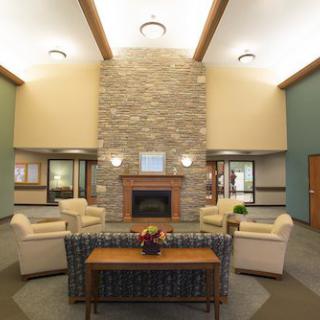 A modern and cozy lounge area featuring a central fireplace and comfortable seating.
