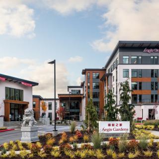 A modern Hilton Garden Inn hotel with landscaped surroundings captured during the daytime.