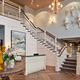 Elegant lobby with a grand staircase and chandelier.