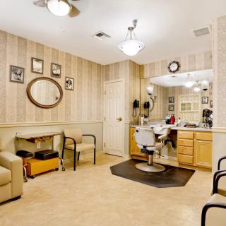 A cozy barber shop interior featuring a styling chair, mirrors, and a waiting area.