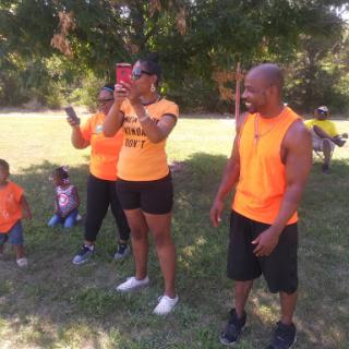 A lively outdoor gathering with family and friends enjoying activities in matching orange outfits.