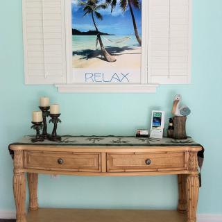 A rustic wooden table adorned with decorative items and a relaxing beach-themed artwork on the wall.