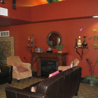 A cozy living room featuring a fireplace, comfortable seating, and warm-toned decor.
