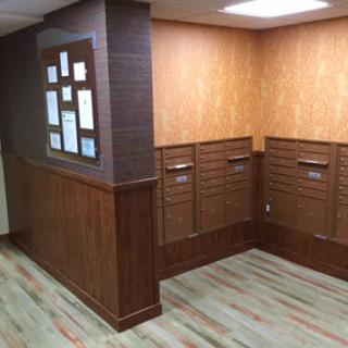 A modern lobby area featuring mailboxes and stylish wood accents.