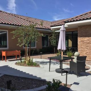 A cozy patio area with outdoor seating and a garden.