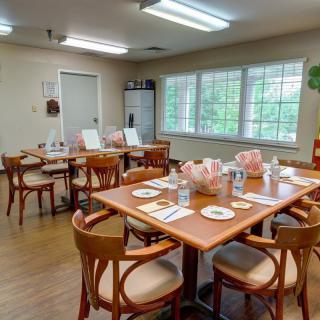 A well-lit dining area with neatly arranged tables and chairs.