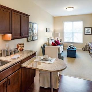A cozy apartment interior featuring a small kitchen and living room area with modern furnishings.