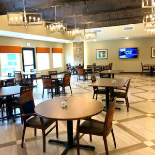 A spacious and modern dining area featuring elegant lighting and comfortable seating.