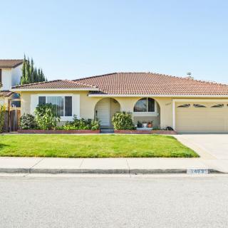 A single-story suburban house with a well-maintained front lawn and a spacious driveway.