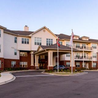 A multi-story residential building with flags at the entrance.