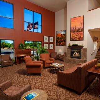 A spacious and inviting lobby with comfortable seating, a fireplace, and large windows allowing natural light.