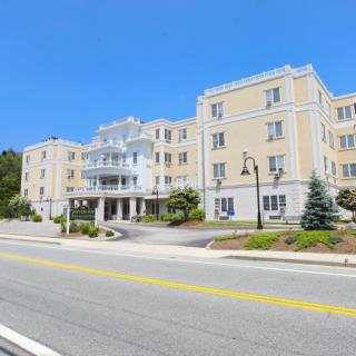 A large residential building with a road in front under a clear blue sky.