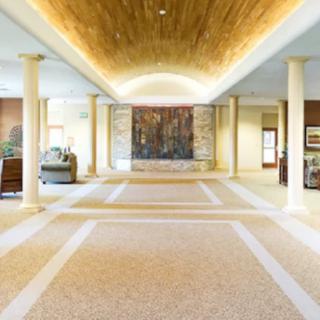 A spacious lobby with columns and an intricate ceiling design.