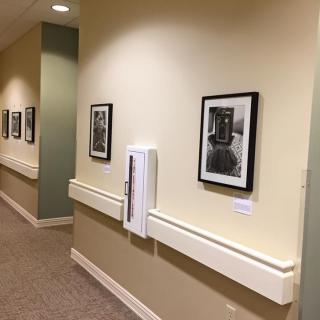 A well-lit hallway with framed photographs displayed on the walls.