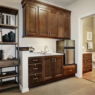 A cozy kitchen nook featuring wooden cabinets, a mini fridge, and a sink.